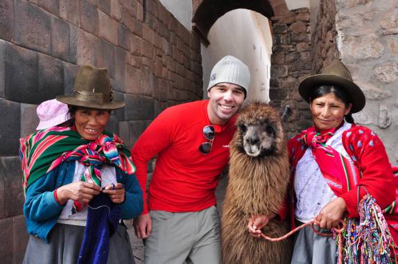 Foto tradicional nas ruas de Cusco, no Peru, com uma lhama e algumas cholas